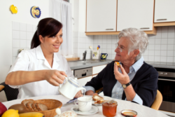 Nurse assisting her elder female patient to eat